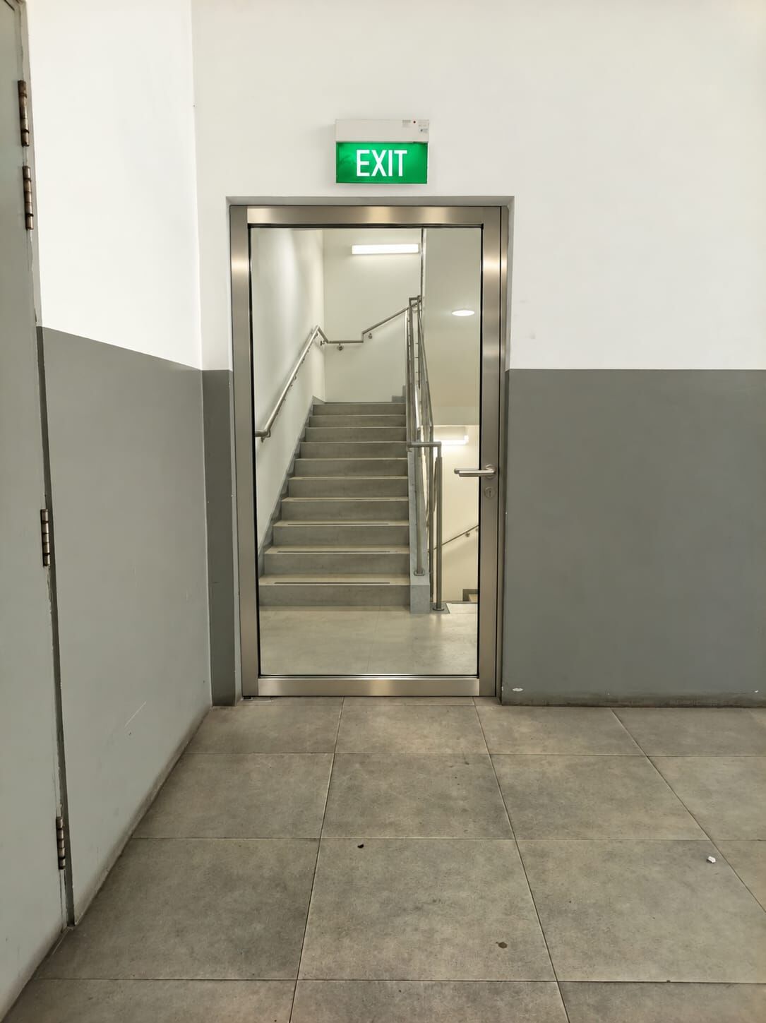 After: fire-rated glass exit door showing the staircase